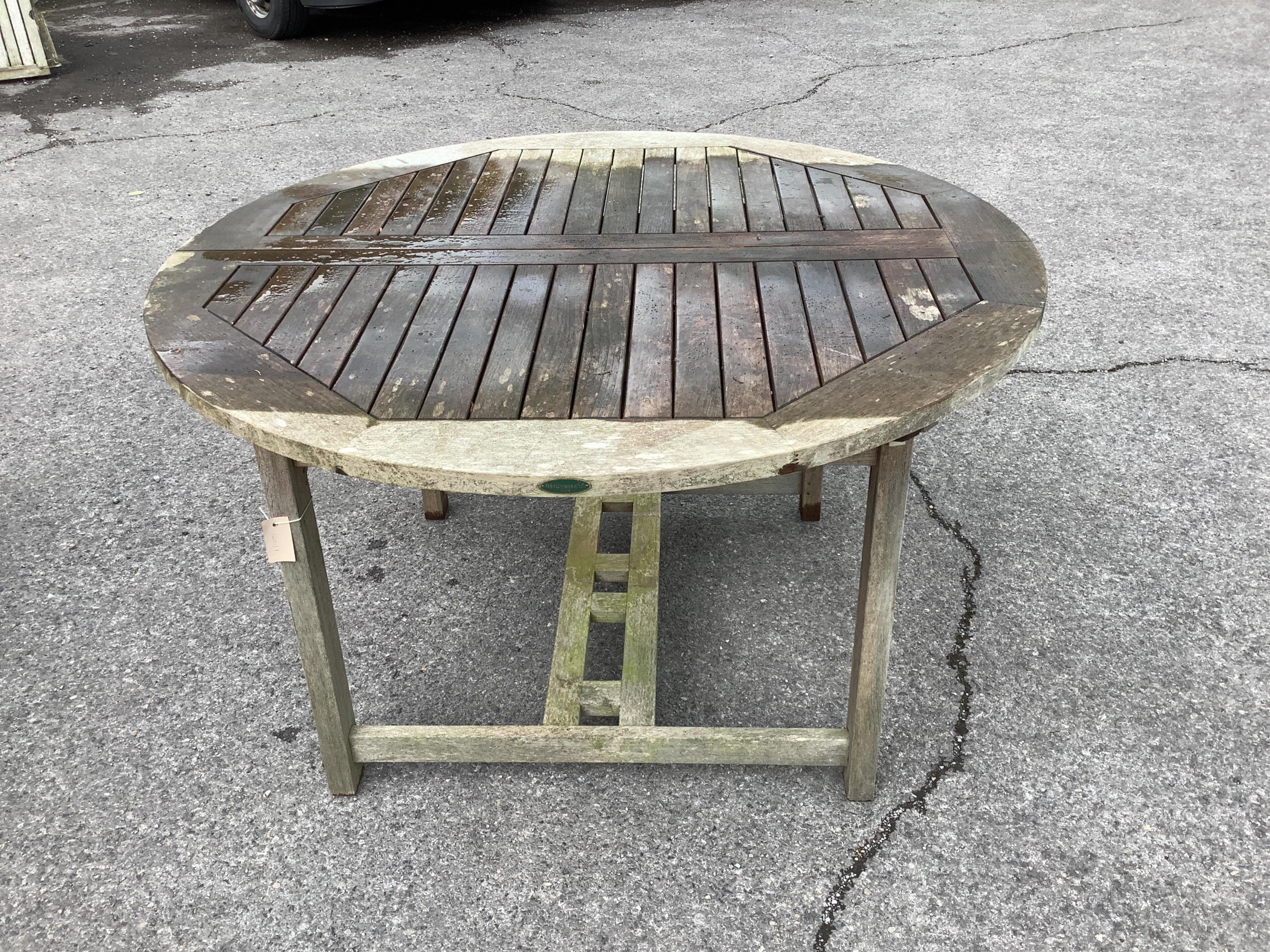 A Westminster circular weathered teak extending garden table, (leaf not functioning correctly), diameter 120cm, height 75cm. Condition - fair